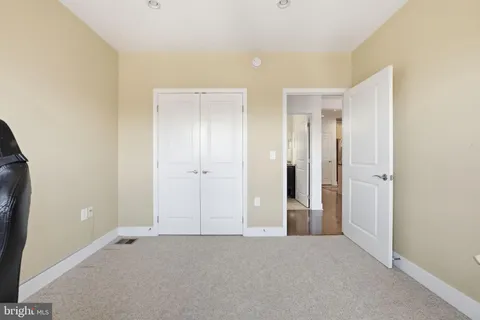an empty room with closet and mirror