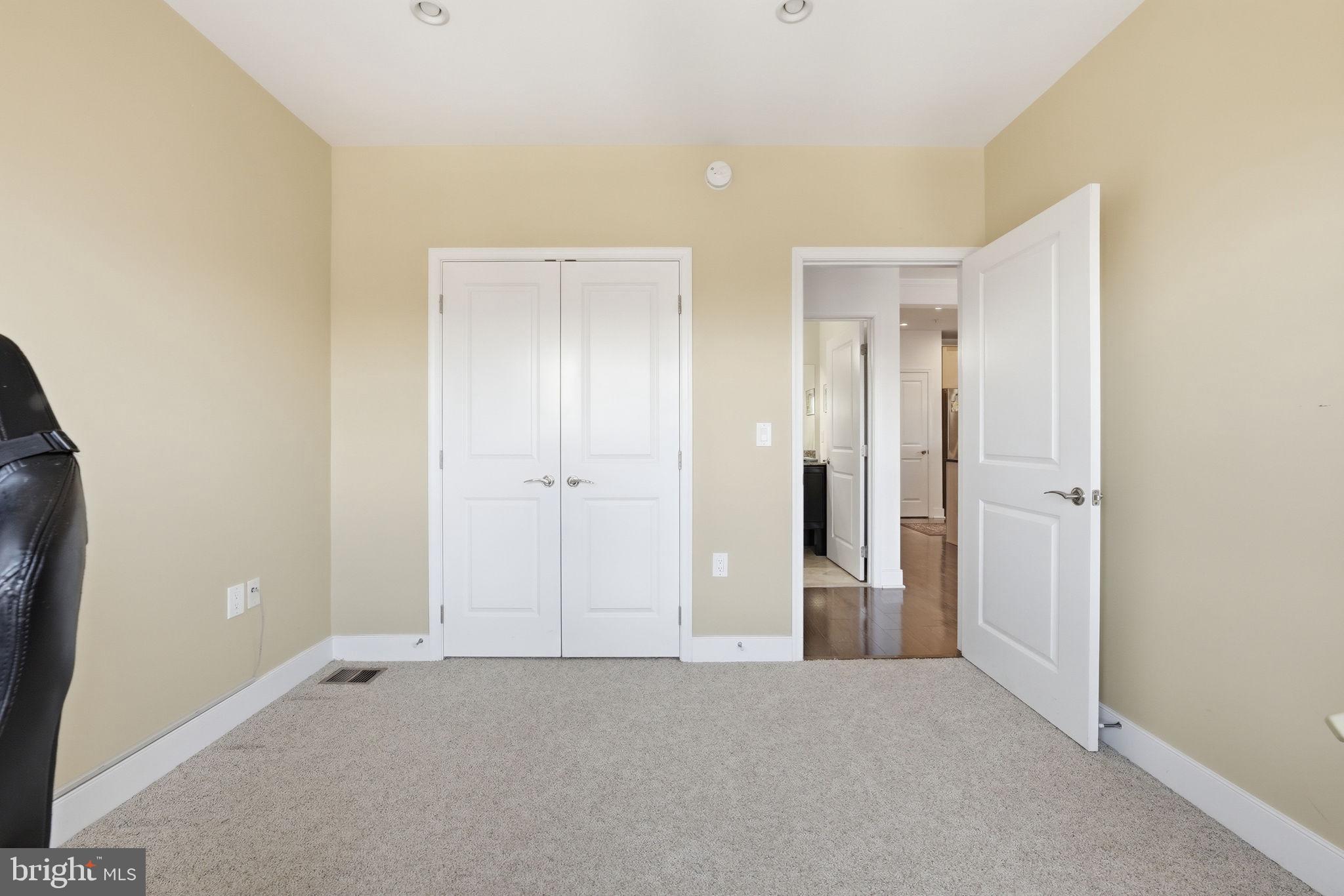 1511 North Rolfe Street, Unit A303 Arlington, VA 22209 - Photo 15 of 21 an empty room with closet and mirror