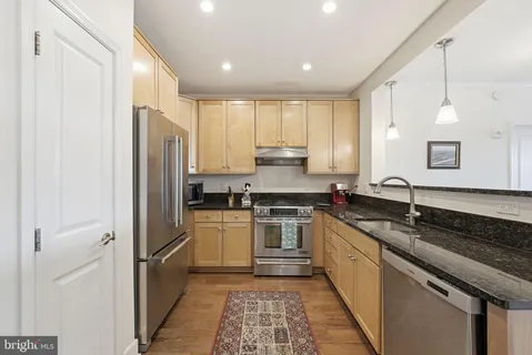 a kitchen with a refrigerator sink and cabinets