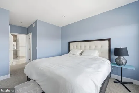 a large bed sitting in a bedroom and a lamp