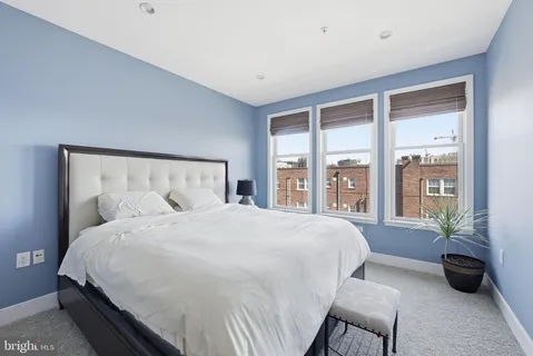 a large bed sitting in a bedroom next to a large window