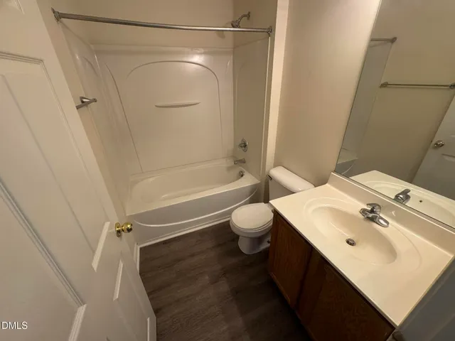 a bathroom with a sink mirror vanity and toilet
