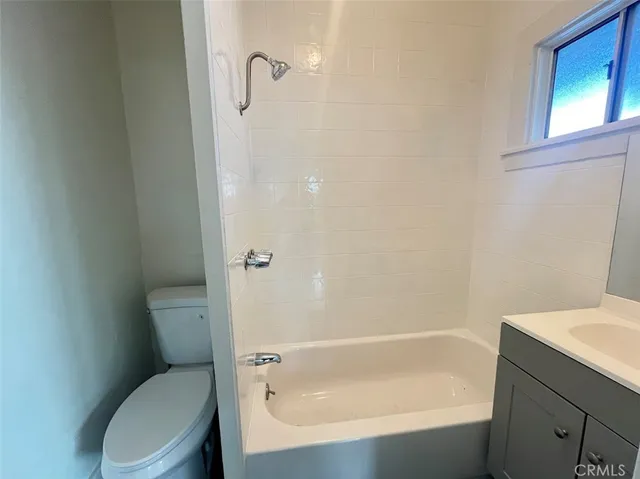 a white toilet sitting next to a bath tub
