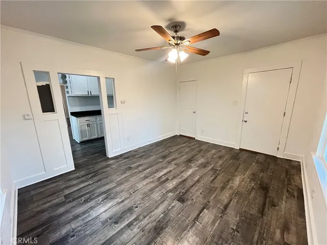 a view of a livingroom with wooden floor and a ceiling fan