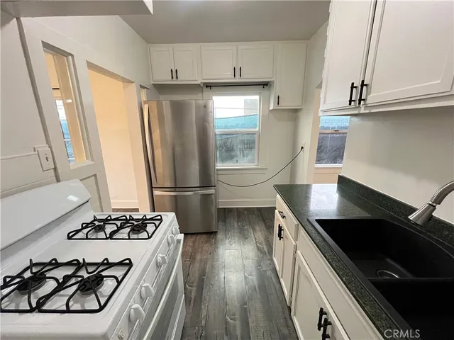 a kitchen with stainless steel appliances a sink a stove a refrigerator and cabinets