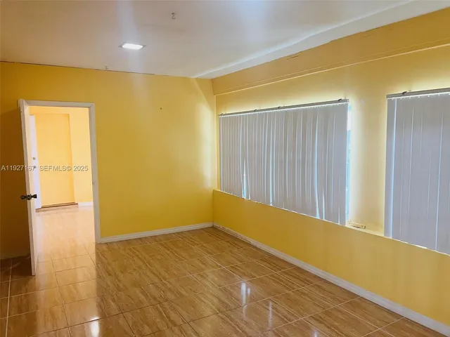 a view of a big room with wooden floor and windows