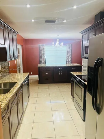 a kitchen with stainless steel appliances granite countertop a sink and a stove