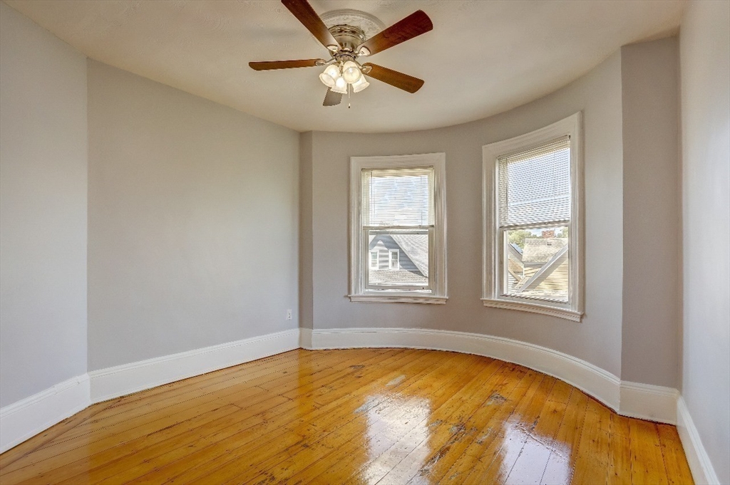83 Topliff Street, Unit ALL Boston, MA 02122 - Photo 12 of 25 a view of an empty room with chandelier fan and a window
