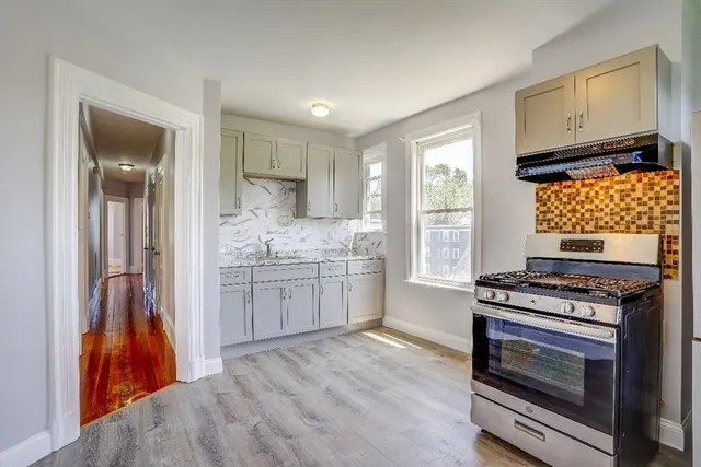 a kitchen with a stove and white cabinets