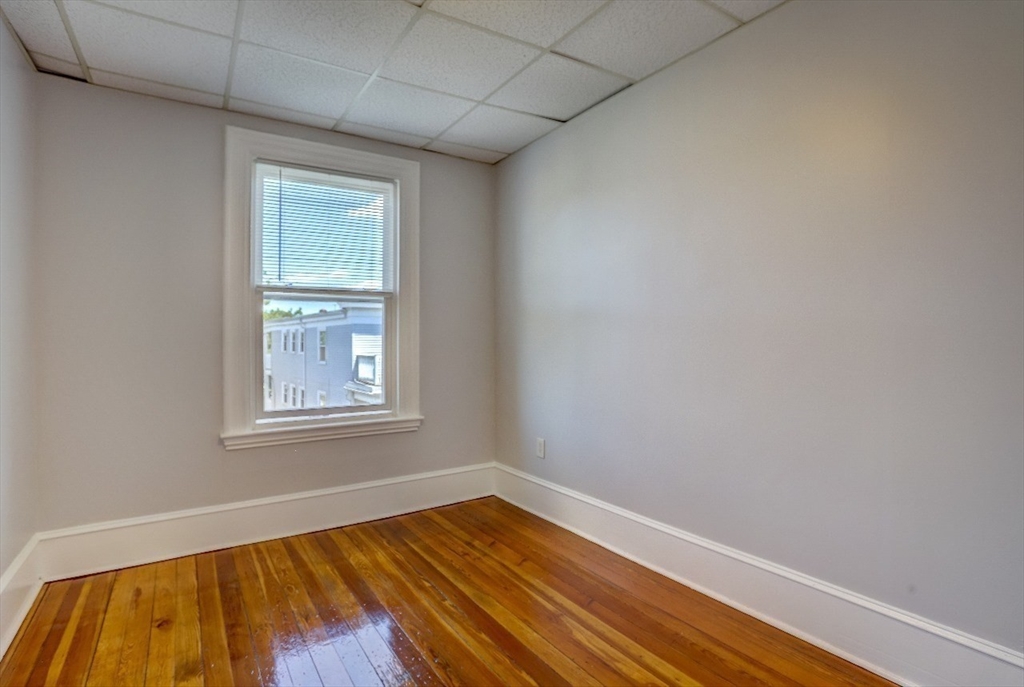 83 Topliff Street, Unit ALL Boston, MA 02122 - Photo 19 of 25 an empty room with wooden floor and windows