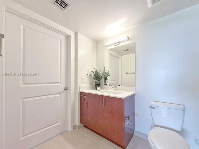 a bathroom with a sink a toilet a mirror and shower