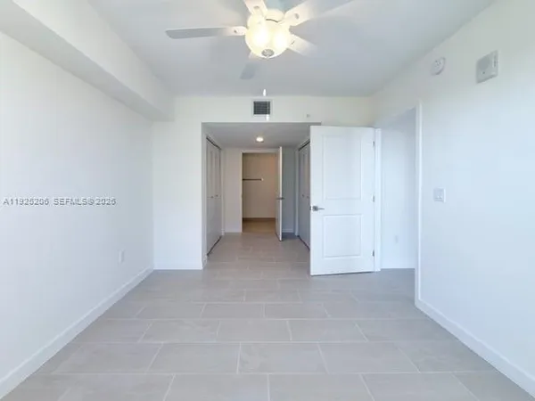 an empty room with a ceiling fan and a window