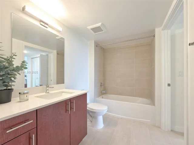 a view of a hallway with a livingroom and a bathroom