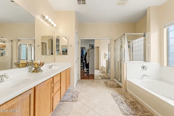 a spacious bathroom with a tub sink and mirror