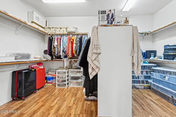 a view of walk in closet with clothes and shoes