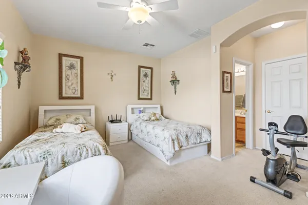 a bedroom with two beds and a chandelier