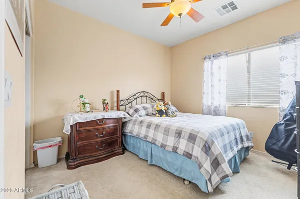 a spacious bedroom with a bed and a chandelier
