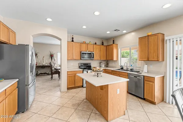 a kitchen with a sink a counter top space a refrigerator and cabinets