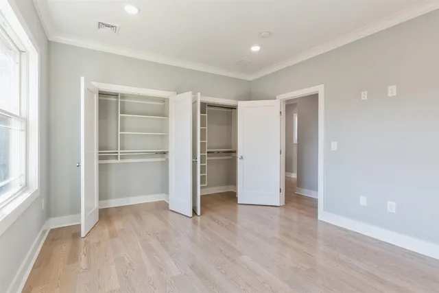 a view of empty room with wooden floor and window