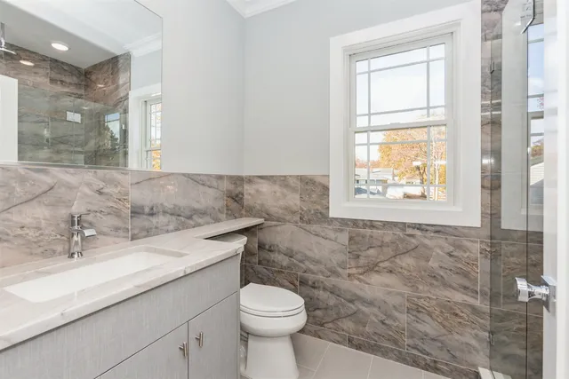 a bathroom with a toilet sink and mirror