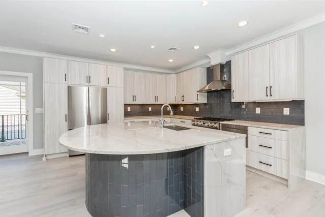 a kitchen with stainless steel appliances granite countertop a sink a stove a refrigerator a white table and chairs