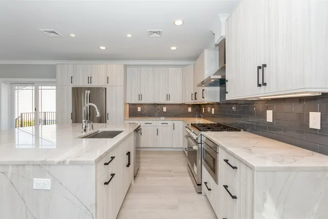 a kitchen with granite countertop white cabinets and white appliances