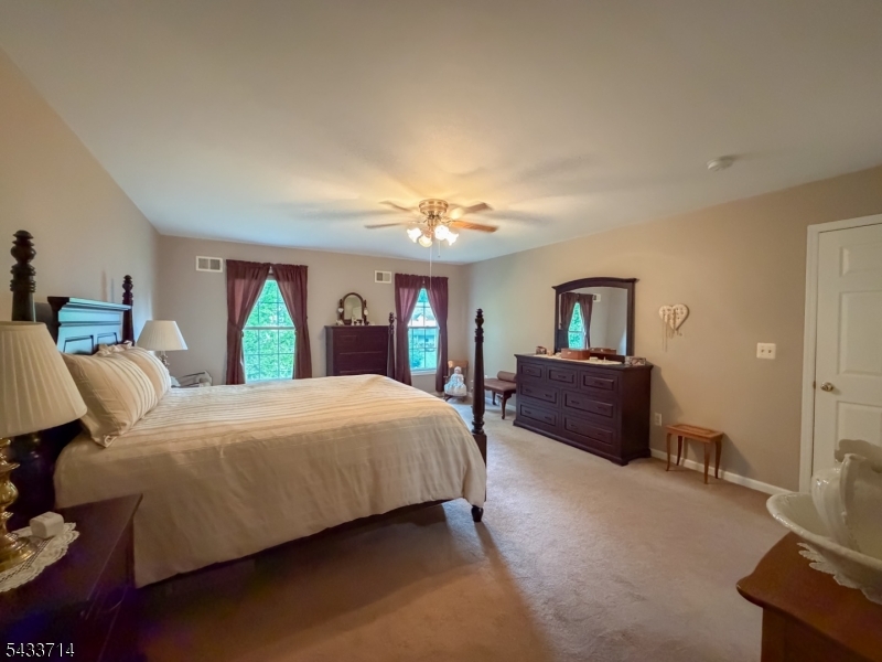 29 Lark Lane Oak Ridge, NJ 07438 - Photo 15 of 26 a bedroom with a large bed and a chandelier