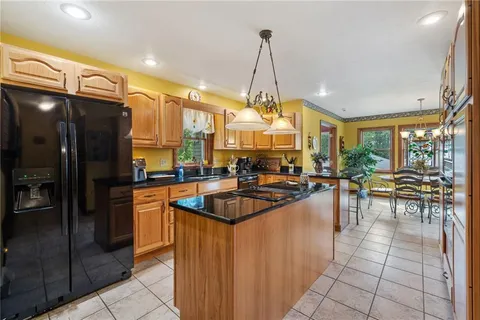 a kitchen with stainless steel appliances granite countertop a sink a counter and chairs