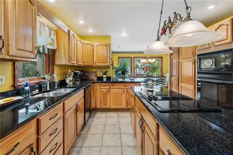 a kitchen with stainless steel appliances granite countertop sink stove and cabinets