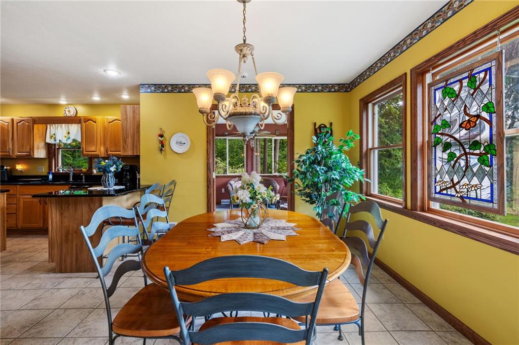 3746 Matthews Road Edinburg, PA 16116 - Photo 23 of 36 a view of a dining room with furniture a chandelier and large windows