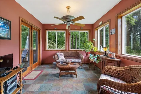 a living room with furniture a ceiling fan and a flat screen tv