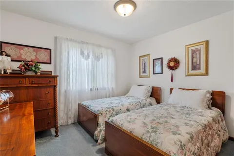 a bedroom with two beds and painting on the wall