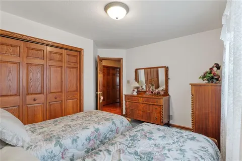 a bedroom with a bed and dresser with mirror