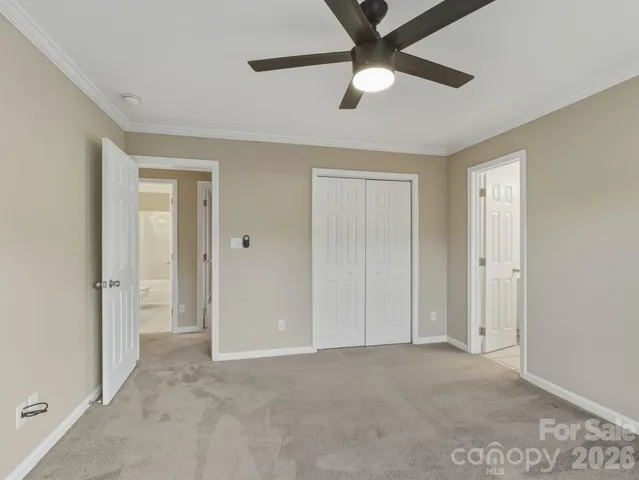 a view of an empty room and chandelier fan