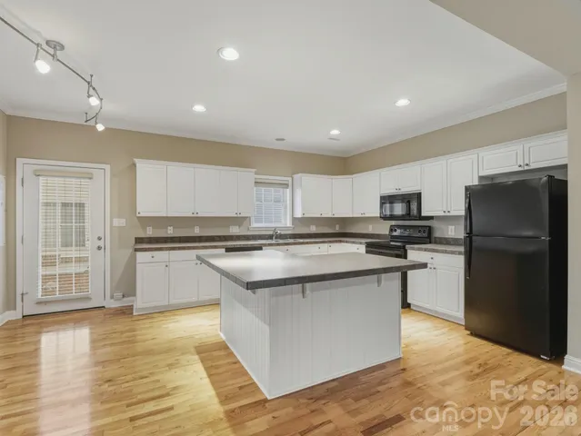 a kitchen with stainless steel appliances granite countertop a refrigerator and a stove top oven