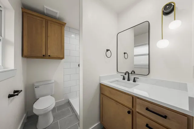 a bathroom with a sink toilet and mirror