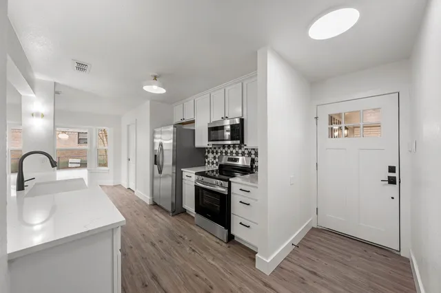 a kitchen with a sink cabinets stainless steel appliances and a window