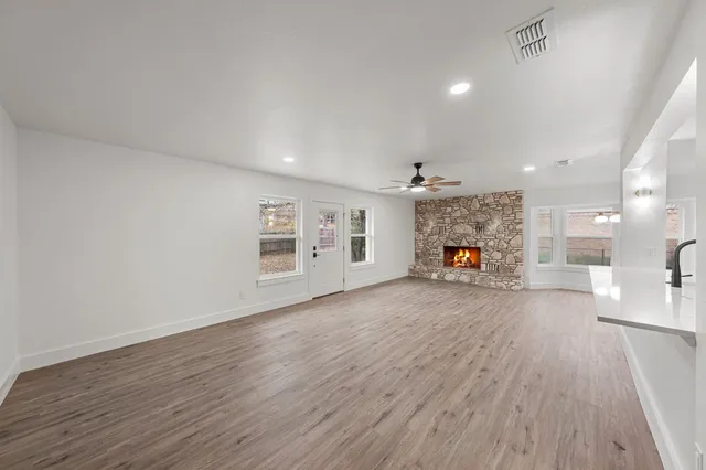 a view of a hallway with wooden floor and a fireplace