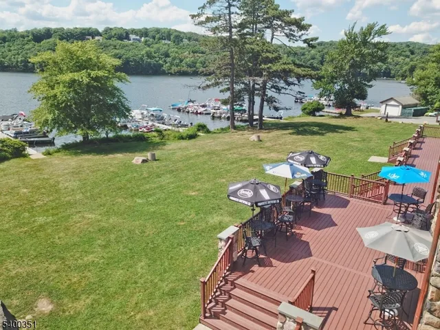 a view of a swimming pool and lounge chairs in back yard of the house