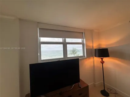 a room with a large window and palm tree