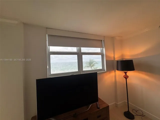 a room with a large window and palm tree