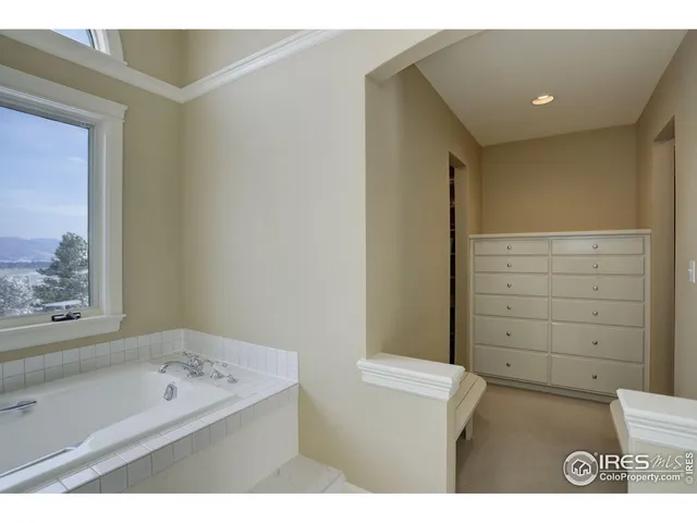 a bathroom with a tub a sink and a large mirror