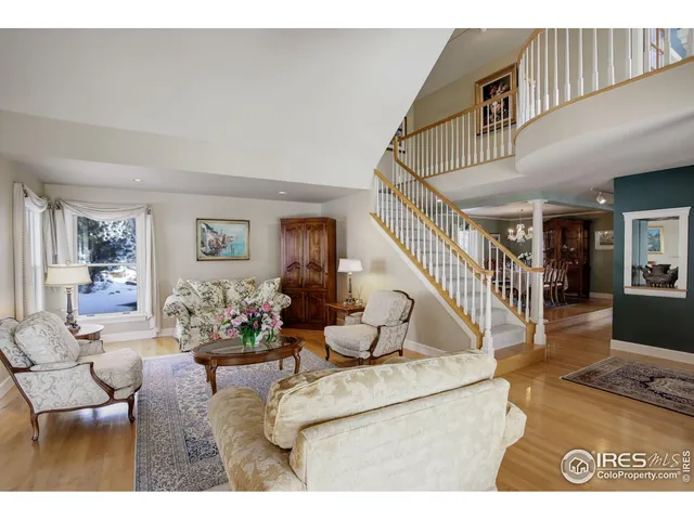 a living room with furniture and a dining table with wooden floor