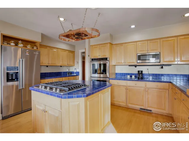 a kitchen with stainless steel appliances granite countertop a stove a sink dishwasher and a refrigerator