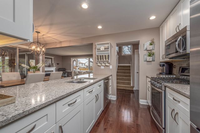 a kitchen with stainless steel appliances granite countertop a stove and cabinets