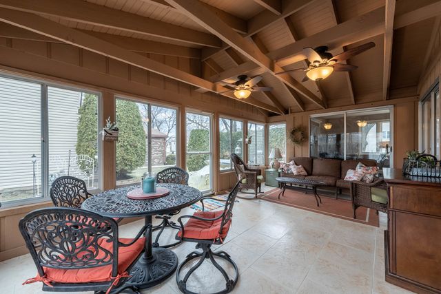 a living room with furniture a ceiling fan and a large window