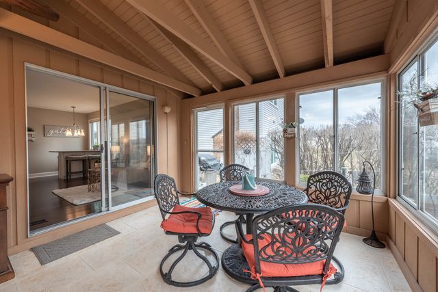 a dining room with furniture large windows and wooden floor