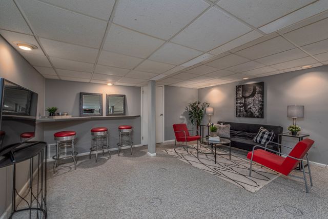 a living room with patio furniture and a flat screen tv