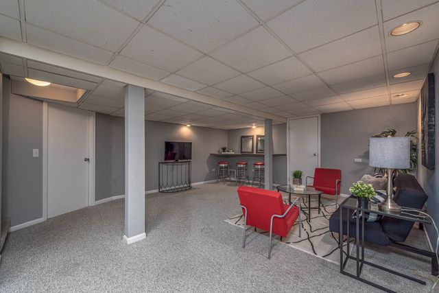 a living room with furniture a fireplace and kitchen view