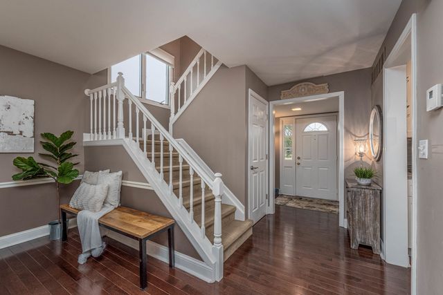 a view of a hallway with wooden floor and stairs